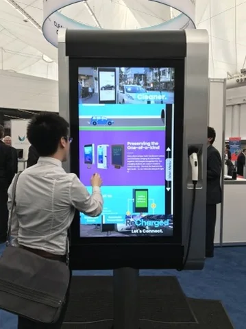 A visitor using the touchscreen on a historical ReCharged Smart-Hub prototype